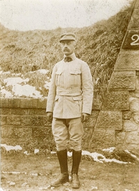 Photographie noir et blanc de Georges Besnier en uniforme de lieutenant, posant devant un talus.