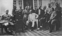 Photographie noir et blanc montrant un groupe d'hommes civils et militaires.