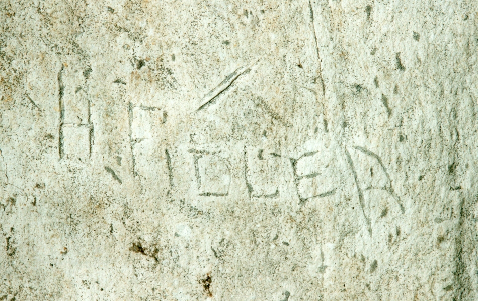 Photographie couleur montrant un graffiti gravé dans la pierre.