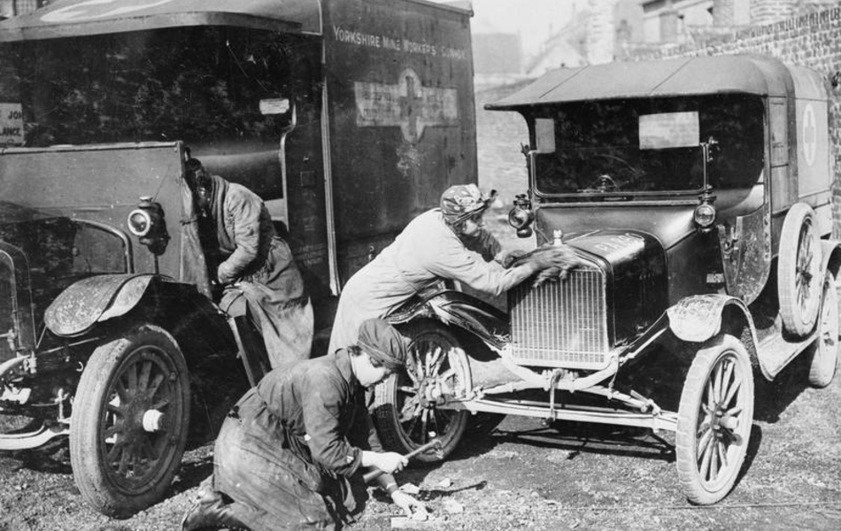 Photographie noir et blanc montrant un camion et une voiture que nettoient deux femmes.