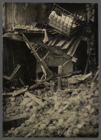 Photographie noir et blanc montrant une maison éventrée par un bombardement.