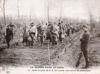 Carte postale noir et blanc montrant un convoi de prisonniers sur un chemin.