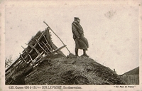 Carte postale noir et blanc montrant un homme guettant au loin sur un talus.