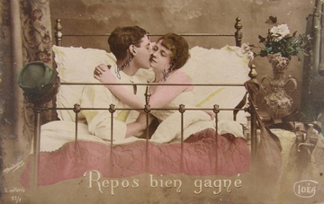 Carte postale couleur montrant un couple enlacé dans un lit.