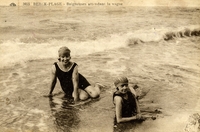 Carte postale noir et blanc montrant deux baigneuses assises en bord de mer.