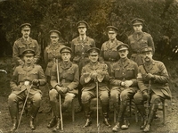 Photographie noir et blanc montrant un groupe de militaires posant sur deux rangs devant un photographe.
