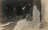 Carte postale noir et blanc montrant une église éventrée par un obus. Des soldats posent devant le chœur. 