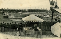 Carte postale noir et blanc montrant 8000 hommes faisant des exercices de gymnastique devant des tribunes où sont assemblés des spectateurs.