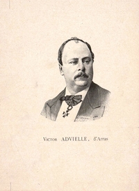 Portrait monochrome d'un homme tourné de trois quart, portant une petite moustache et uninsigne (une décoration) à sa cravate.
