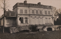 Photographie noir et blanc montrant la façade d'un château aux volets fermés et partiellement détruit.