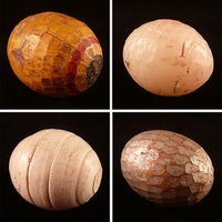 Photographie couleur montrant quatre balles en bois en forme d’œufs.