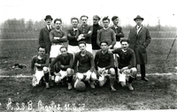 Photographie noir et blanc montrant une équipe de football posant devant un but.