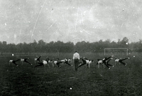 Photographie noir et blanc montrant une équipe faisant de la gymnastique sur un terrain de football