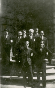 Photographie noir et blanc montrant un homme âgé entouré de jeunes garçons.