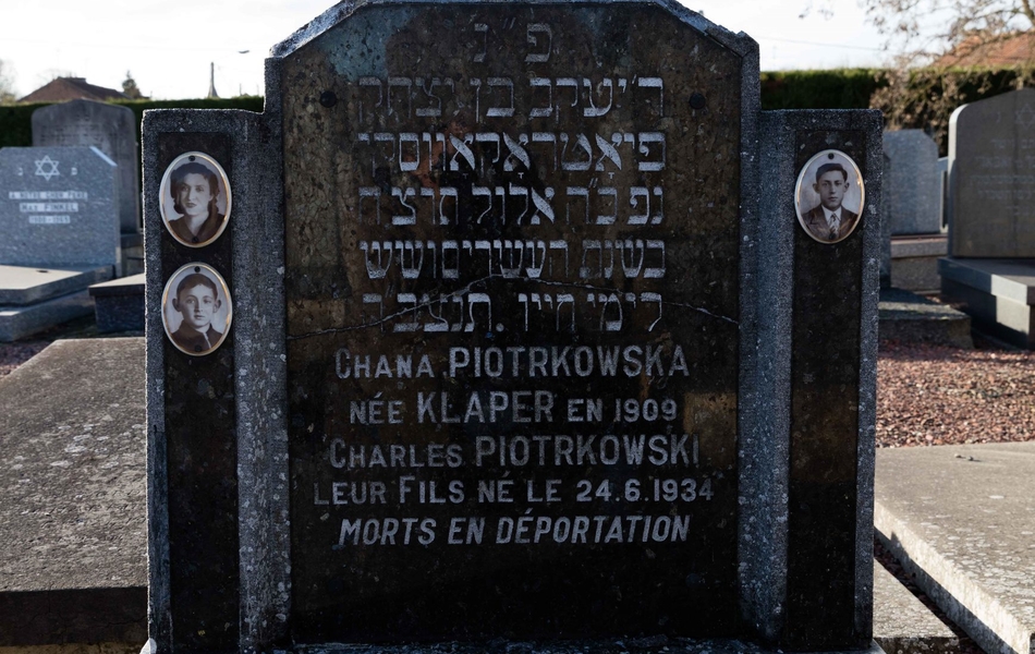Photographie couleur montrant une tombe sur laquelle sont apposées 3 photographies et la stèle suivante : "Chana Piotrkowska née Klaper en 1909, Charles Piotrkowski, leur fils né le 24 juin 1934, morts en déportation".