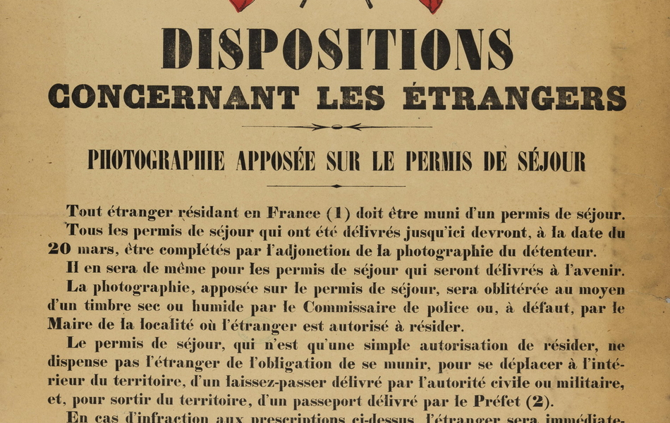 Affiche aux couleurs du drapeau français, sur laquelle on lit : "Dispositions concernant les étrangers. Photographie apposée sur le permis de séjour. Tout étranger résidant en France soit être muni d'un permis de séjour. Tous les permis de séjour qui ont été délivrés jusqu'ici devront, à la date du 20 mars, être complétés par l'adjonction de la photographie du détenteur. Il en sera de même pour les permis de séjour qui seront délivrés à l'avenir. La photographie, apposée sur le permis de séjour, sera oblitérée au moyen d'un timbre sec ou humide par le commissaire de police ou, à défaut, par le maire de la localité où l'étranger est autorisé à résider. Le permis de séjour, qui n'est qu'une simple autorisation de résider, ne dispense pas l'étranger de l'obligation de se munir, pour se déplacer à l'intérieur du territoire, d'un laissez-passer délivré par l'autorité civile ou militaire, et, pour sortir du territoire, d'un passeport délivré par le préfet. En cas d'infraction aux prescriptions ci-dessus, l'étranger sera immédiatement arrêté sous prévention d'espionnage. Signé : le ministre de la Guerre, le ministre de l'Intérieur".