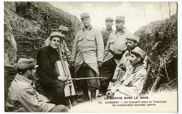 Carte postale noire et blanc où pose un groupe de soldats dans une tranchée, rassemblé autour d'un violoncelliste. L'instrument est fait de matériaux de récupération, la caisse de résonnance, par exemple, semble être une caisse en bois.