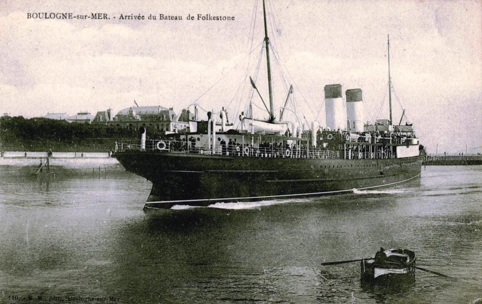 Carte postale noir et blanc représentant l'arrivée d'un paquebot dans le port de Boulogne-sur-Mer. Beaucoup de personnes se trouvent sur le pont