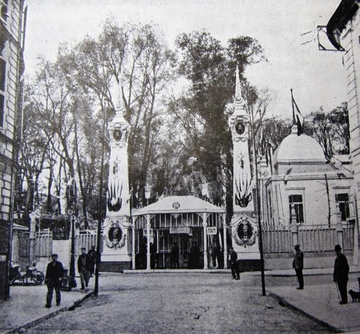 Photographie noir et blanc montrant le guichet de l'entrée de l'exposition au croisement d'une rue. 