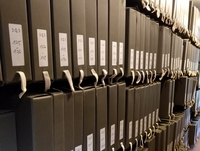 Photographie couleur de boîtes d'archives 3 Q 3 rangées dans le dépôt d'archives.